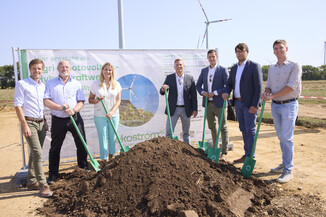 Vertreter der Projektpartner beim Spatenstich für das Agri-PV-Hybridkraftwerk in Parndorf, mit grünen Spaten vor Erdhaufen.