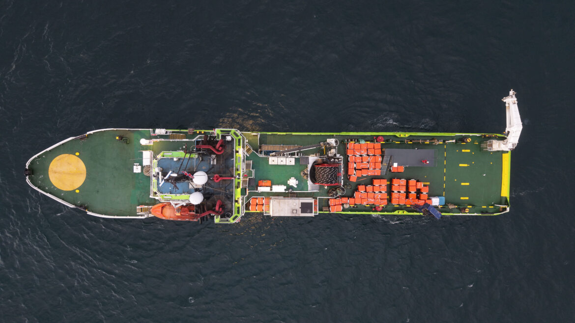 Luftaufnahme eines Versorgungsschiffs mit Fracht an Deck.