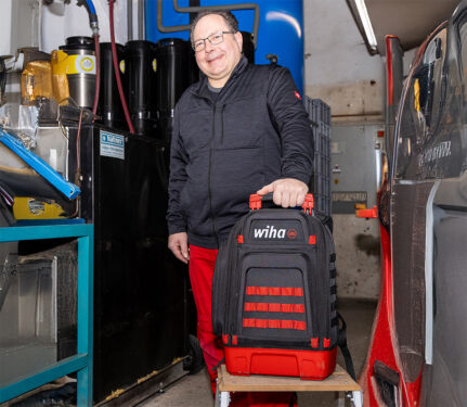 Markus Metzler, Geschäftsführer von Watts Elektrotechnik, steht mit dem Wiha Werkzeugrucksack in einer Werkstatt.