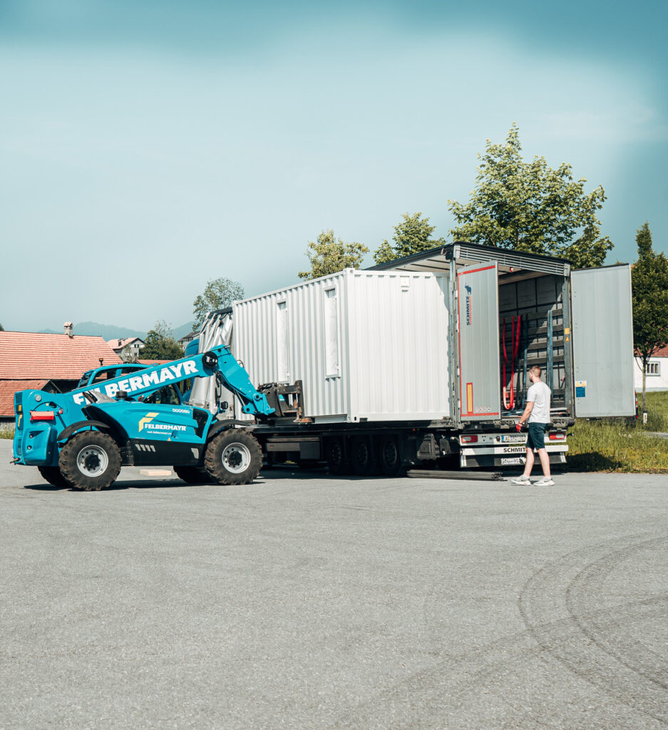 Gabelstapler lädt Energiespeicher-Container von e.battery systems auf einen LKW.