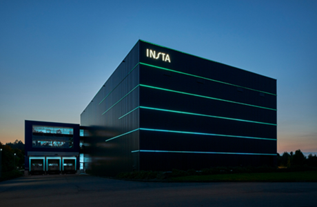 Außenaufnahme des Insta-Gebäudes bei Nacht mit beleuchteten Linien an der Fassade.