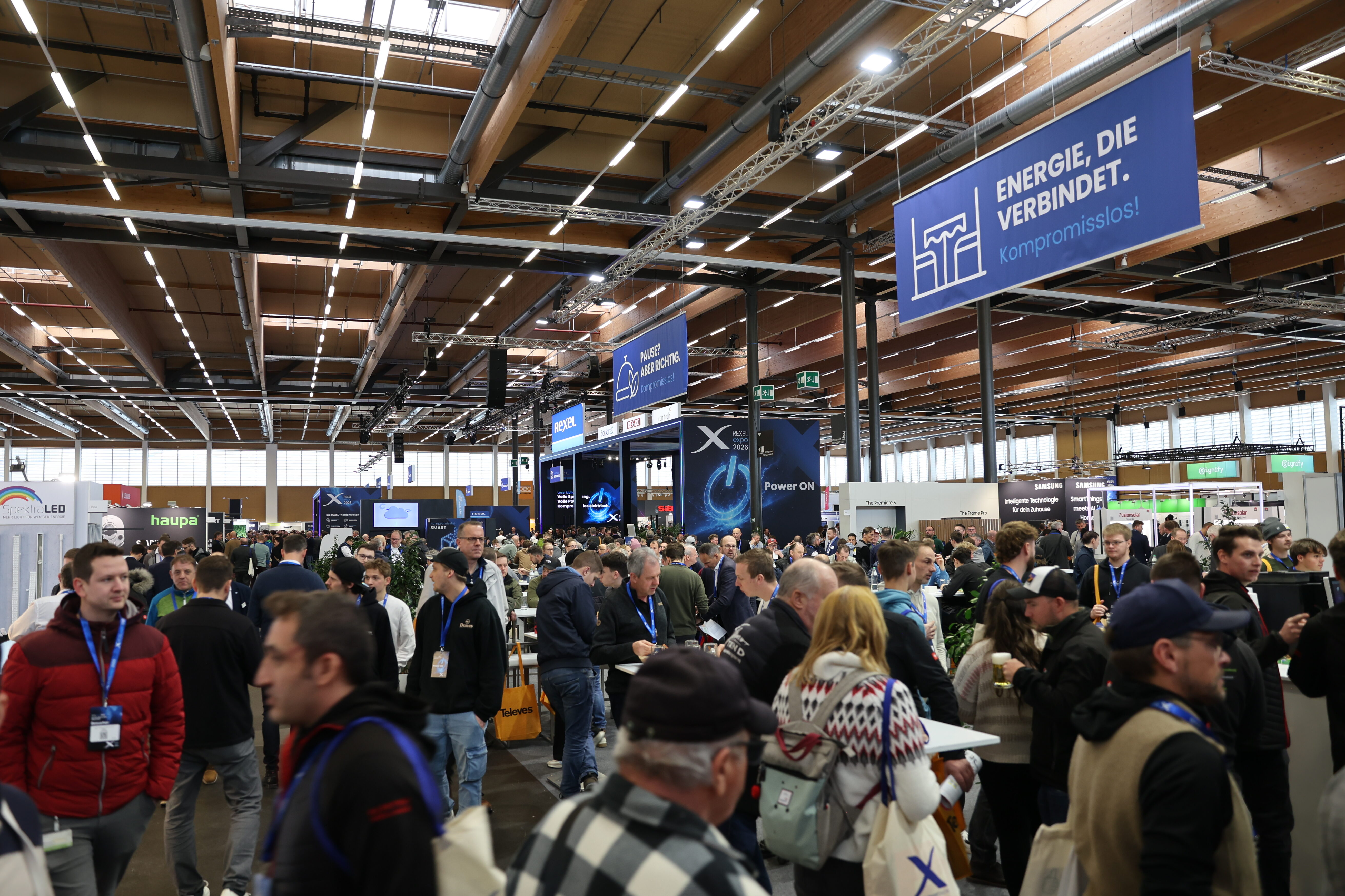 Gut gefüllte Messehalle der Rexel Expo 2026 mit zahlreichen Fachbesucher:innen zwischen Ausstellerständen.