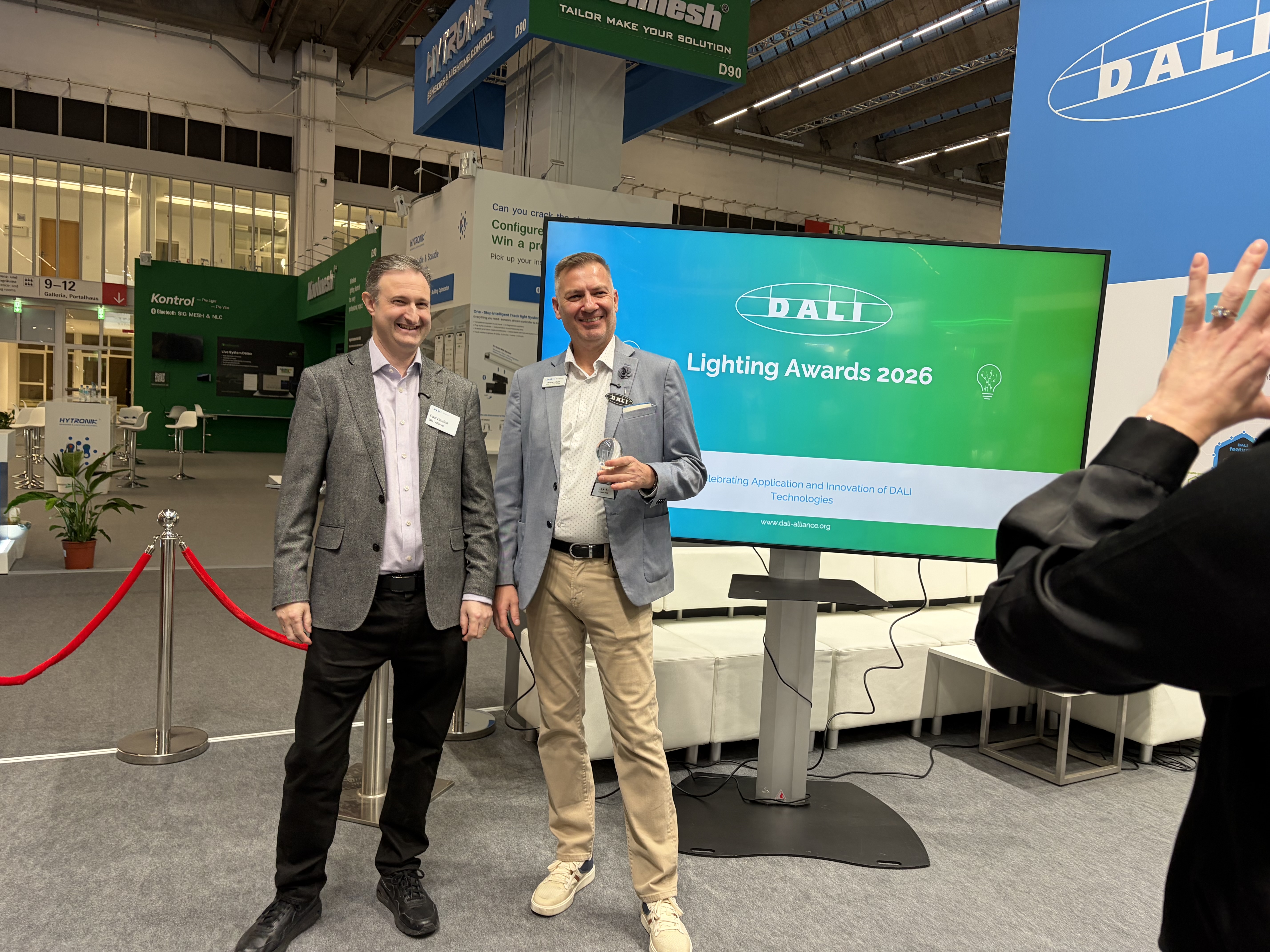 Zwei Vertreter der Dali Alliance präsentieren die Lighting Awards 2026 auf der Messe Light + Building in Frankfurt.