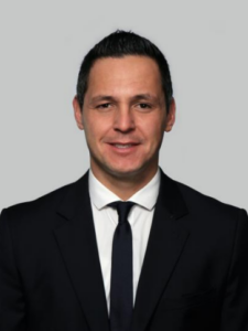 Porträt von Ugur Ünal, Vertriebsleiter Deutschland bei Citel, im dunklen Anzug vor grauem Hintergrund.