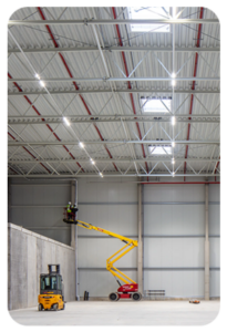 Große Industriehalle mit installiertem LED-Lichtbandsystem und Hebebühne bei der Montage.
