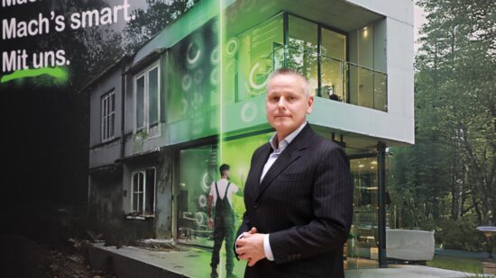 Karl Sagmeister, Country Manager von Schneider Electric Österreich, vor einer Visualisierung zur digitalen Gebäudemodernisierung