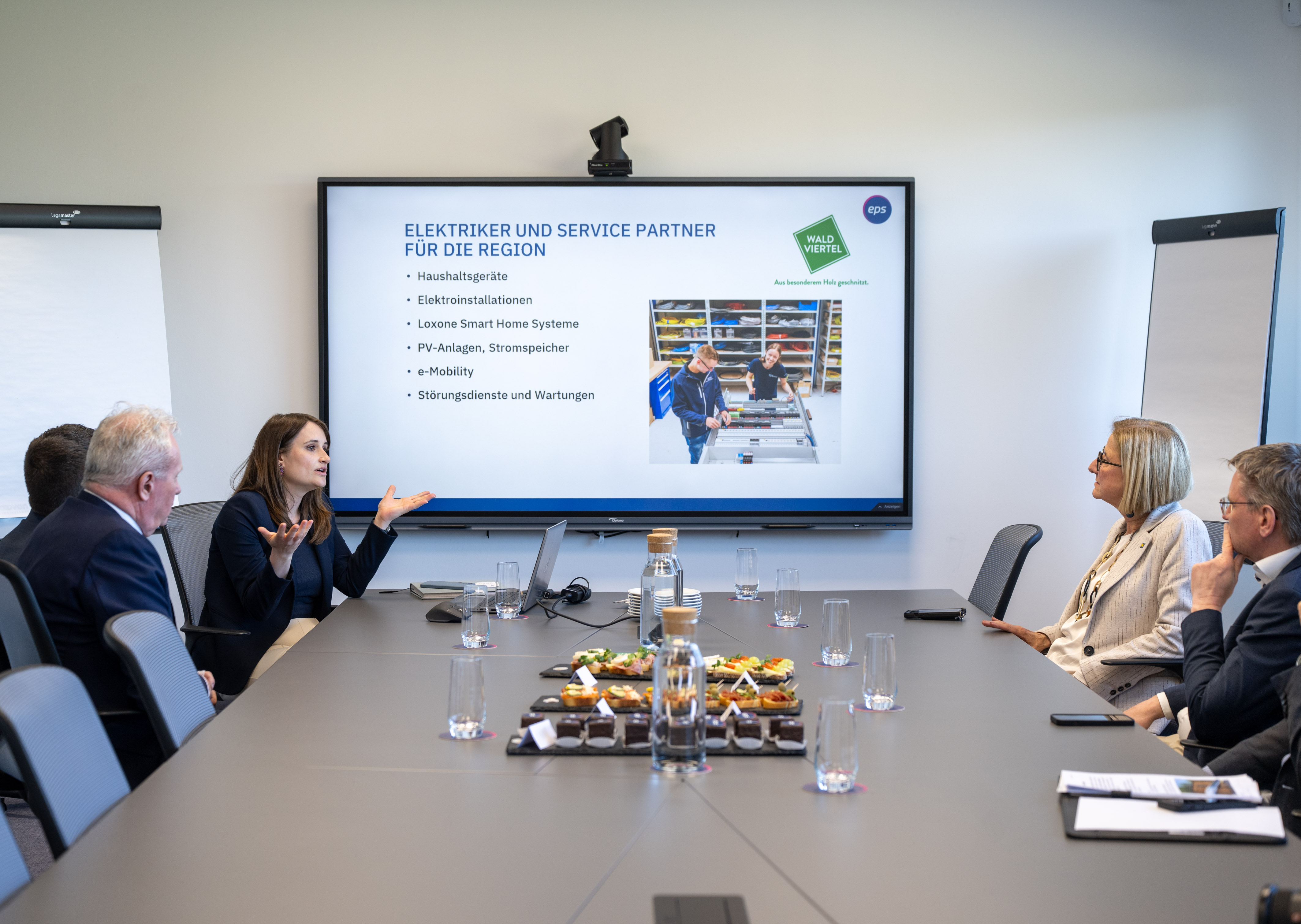 Meeting mit Präsentation zu Elektro- und IT-Services bei EPS, Teilnehmer sitzen an einem Konferenztisch.