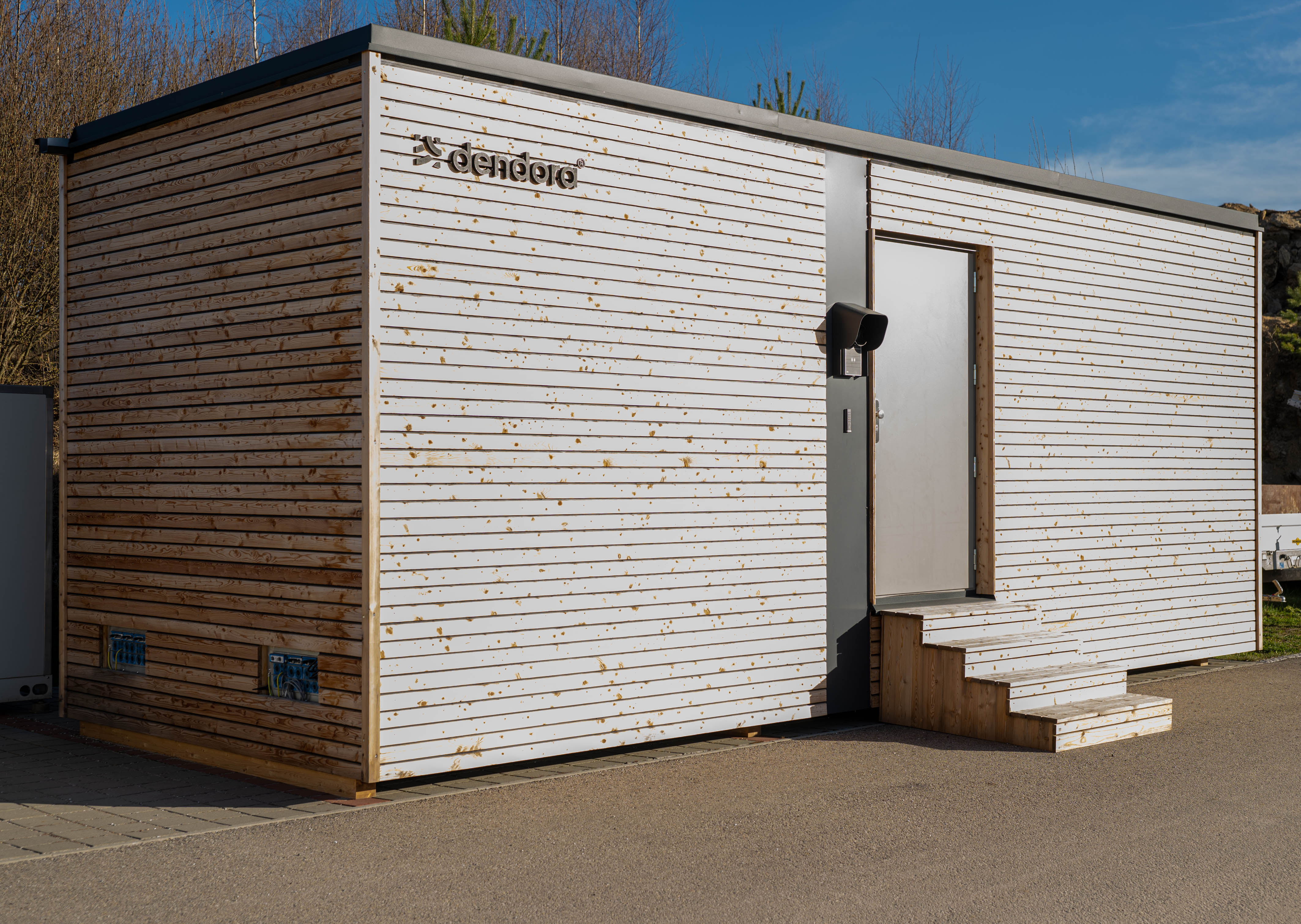 Holzverkleideter, modularer Rechenzentrums-Container dendora im Außenbereich.