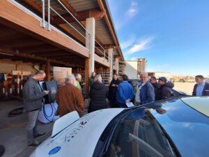 Teilnehmer diskutieren bei Vorführung einer bidirektionalen Ladestation.