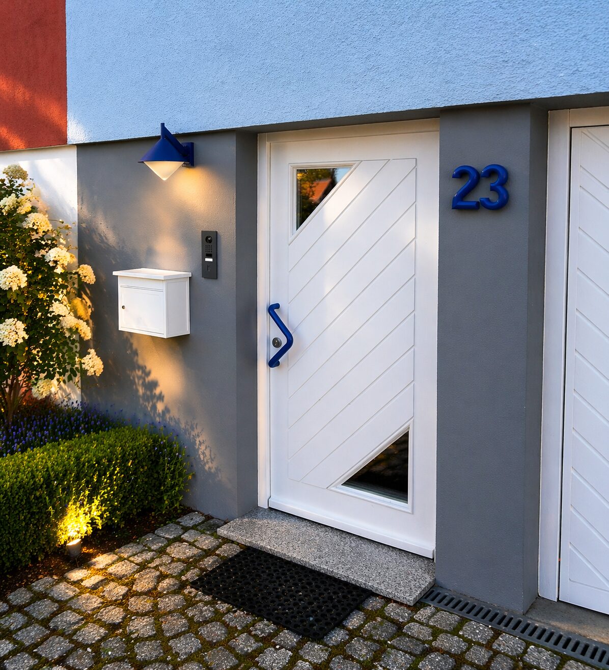 Modernisierte Hauseingangstür mit DoorBird-Türstation und Außenbeleuchtung an einem Reihenhaus.