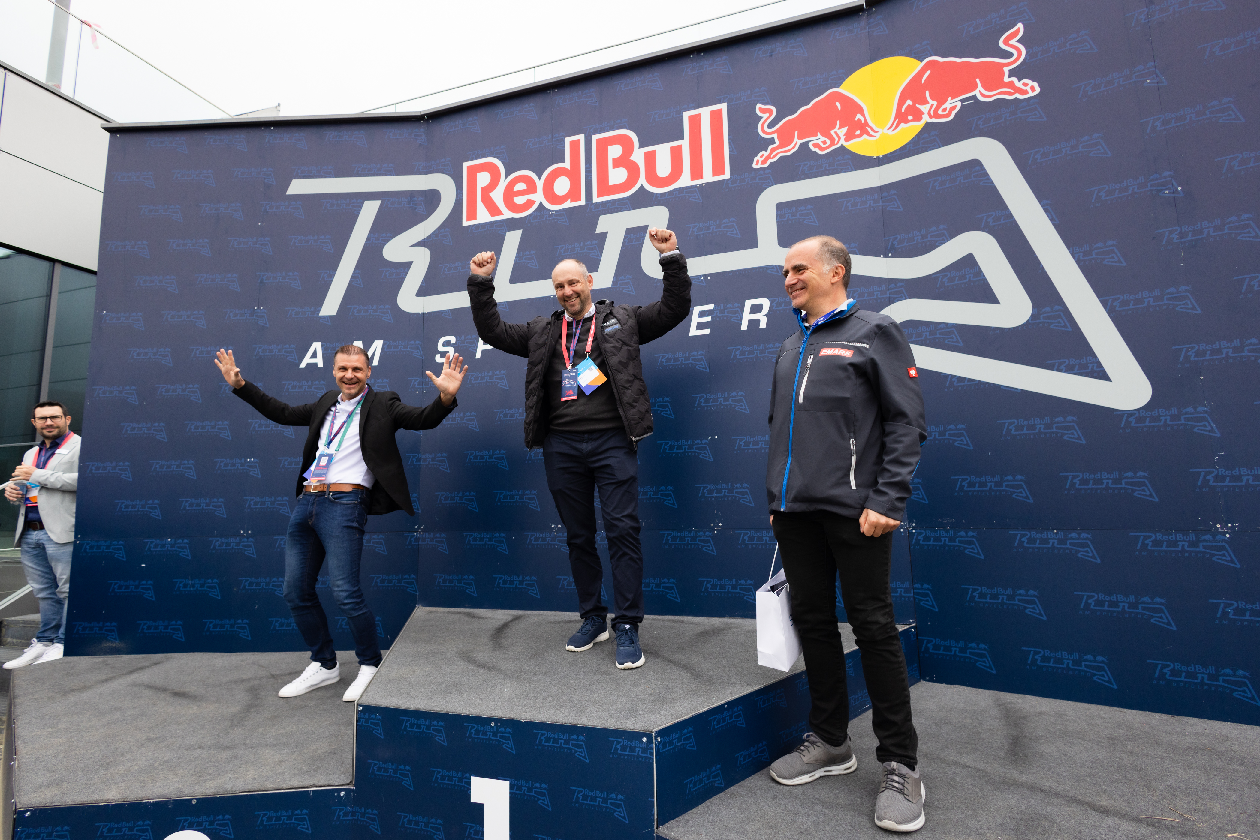 Teilnehmer posieren vor einer Red Bull Ring Fotowand.