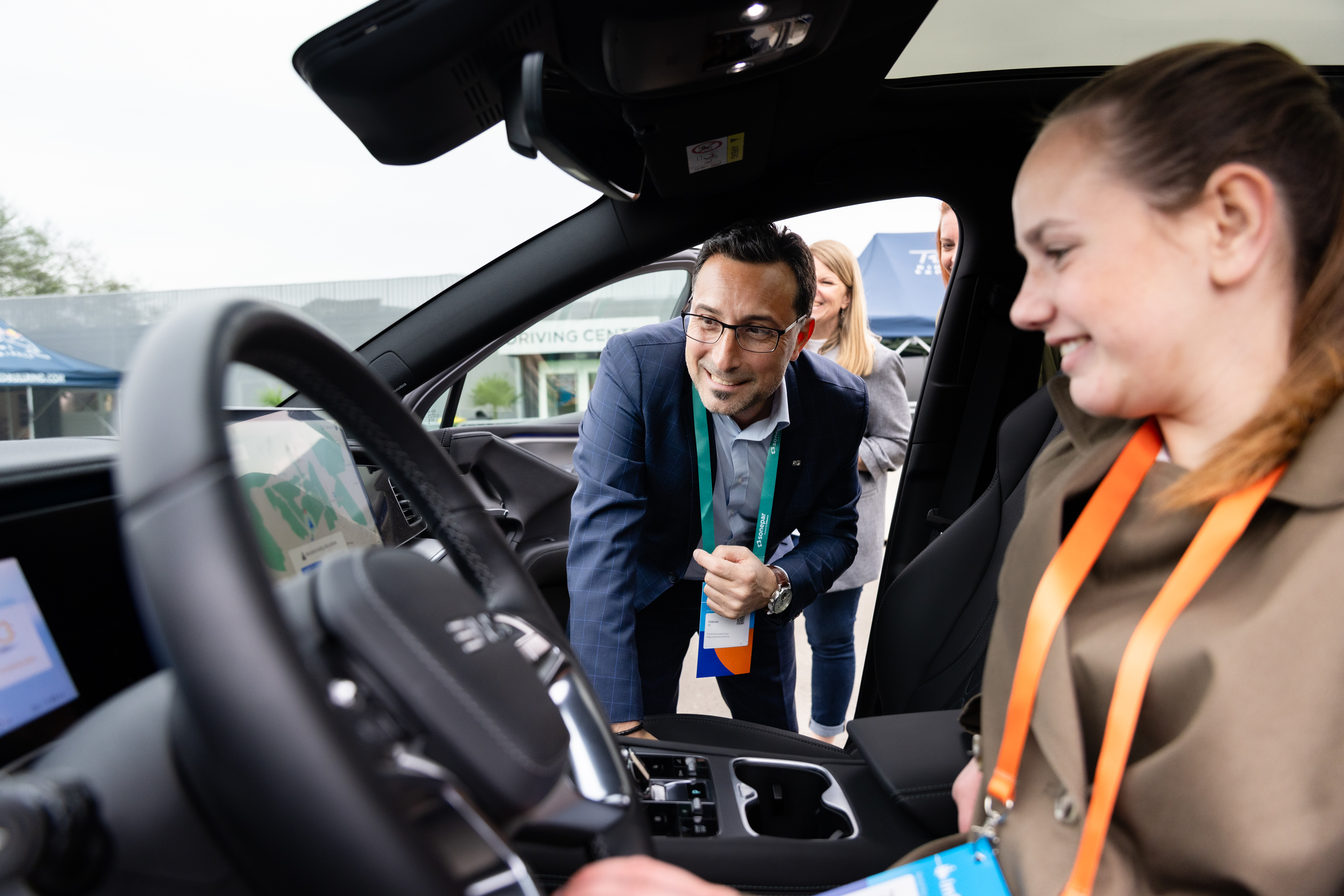 Besucher testen ein Elektrofahrzeug im Außenbereich der Veranstaltung.