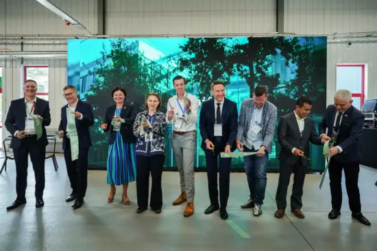 Eröffnung der neuen Signify-3D-Druckfabrik in Piła mit mehreren Personen beim symbolischen Banddurchschnitt.