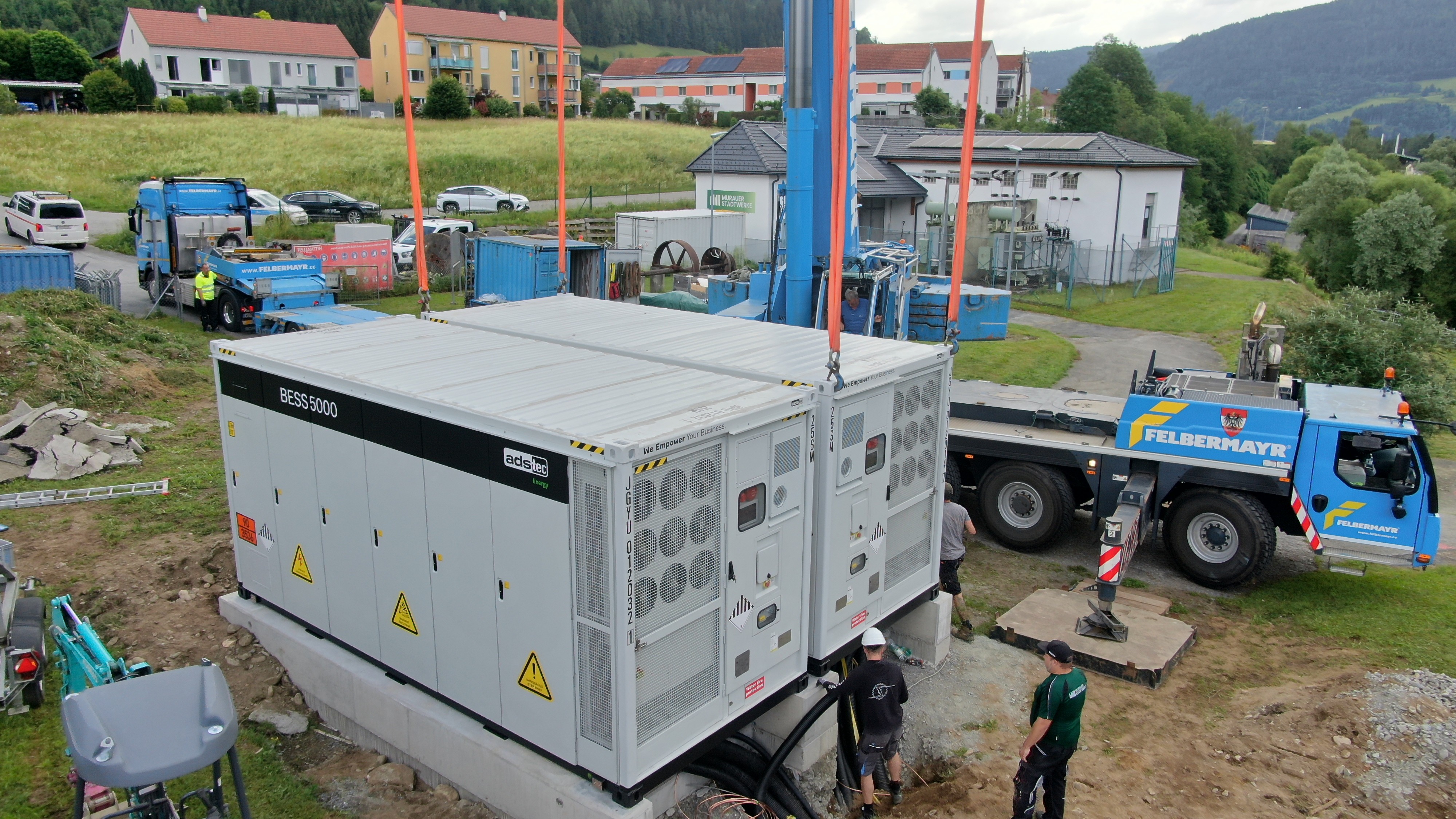 DS-TEC Energy Batteriespeicher wird auf einem Fundament installiert, daneben ein Mobilkran und Montageteam.