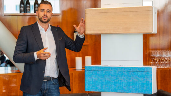 Almir Karagic von Daikin Österreich präsentiert neue Daikin Stylish-Klimageräte in Holz-, Stoff- und Lederoptik.