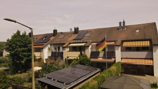 Reihenhäuser mit Photovoltaikmodulen auf Balkon und Dach zur Nutzung von Solarenergie.