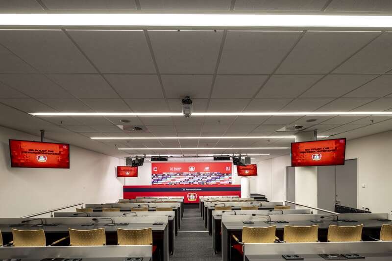 Pressekonferenzraum der BayArena mit blendfreier LED-Beleuchtung und digitalen Bildschirmen.