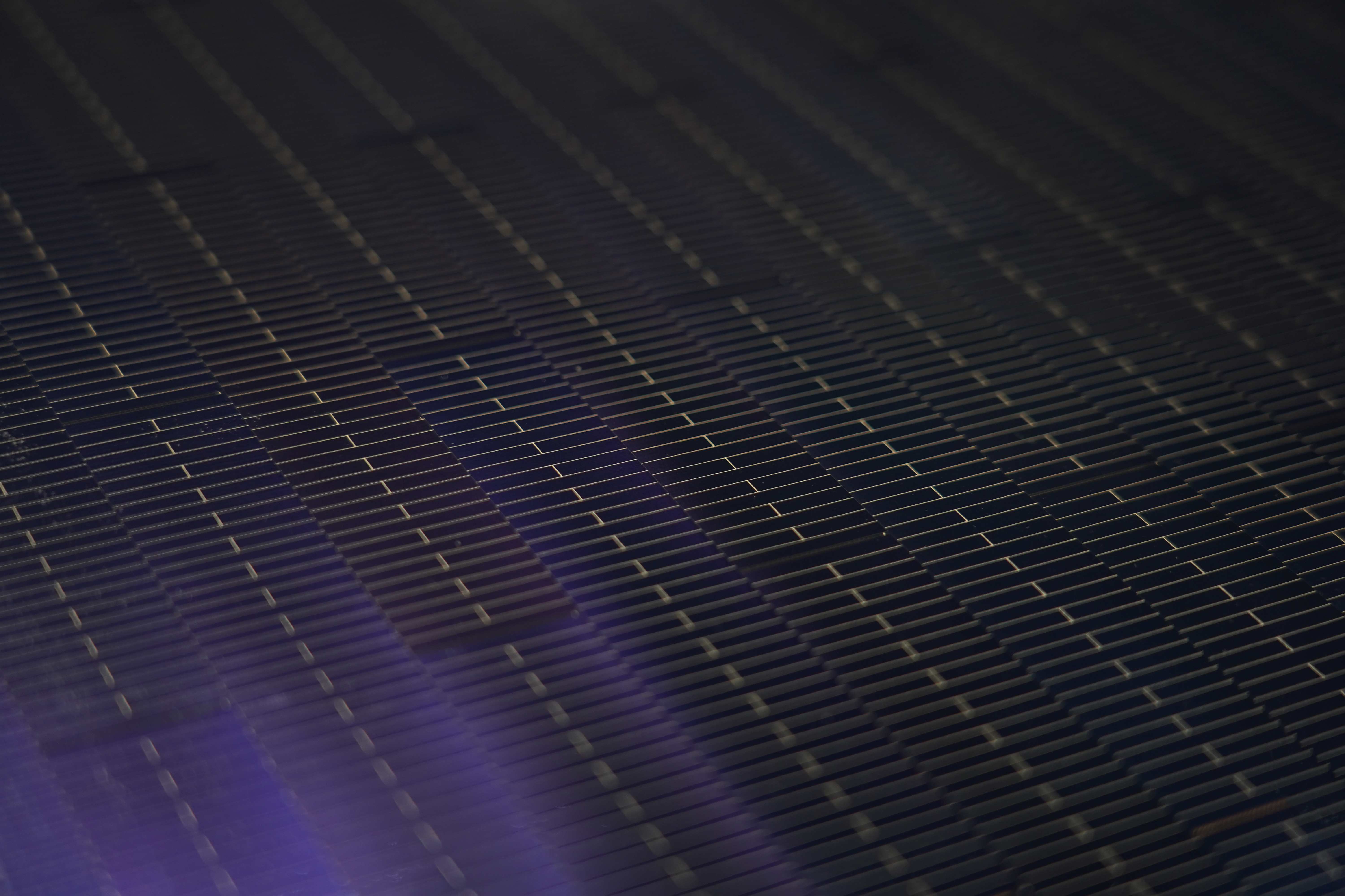 Nahaufnahme der Zellstruktur eines Perowskit-Silizium-Solarmoduls mit feinen Leiterbahnen und rechteckigen Zellsegmenten.