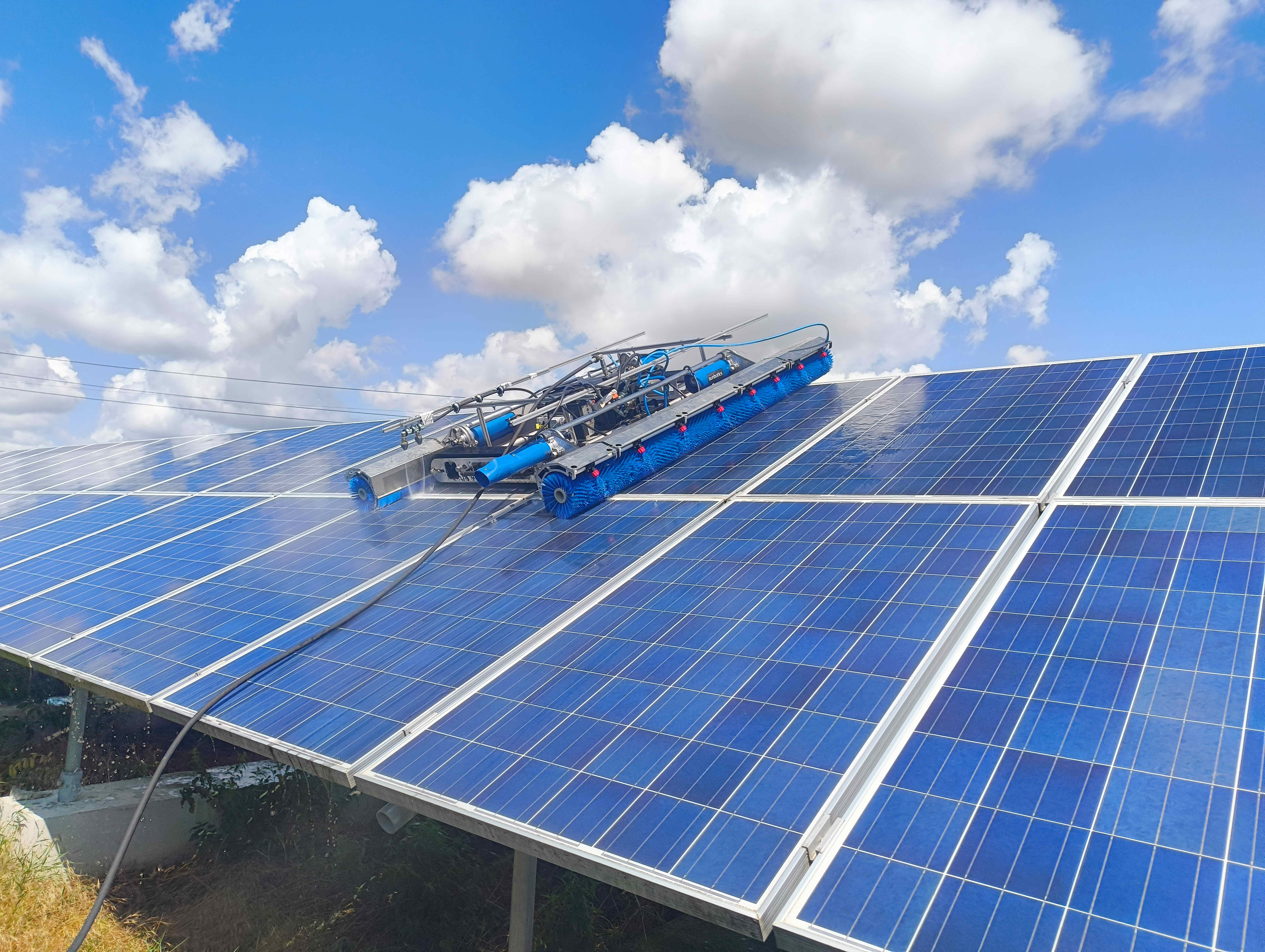 Reinigungsroboter säubert Photovoltaikmodule auf einer Freiflächenanlage.