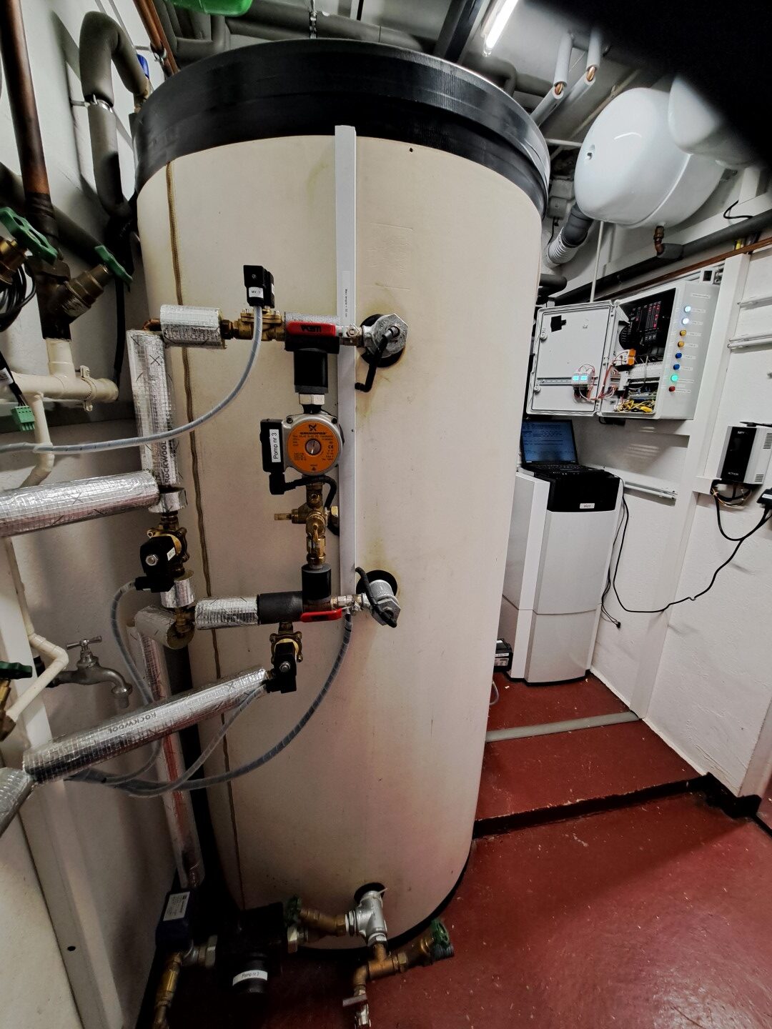 Pufferspeicher mit Rohrleitungen und Regelungstechnik im Heizungsraum